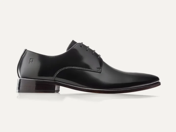 Sapato Derby Classic Plain Toe em couro preto, sobre fundo claro.