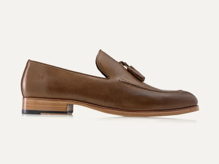 Loafer Neo Tassel na cor conhaque, sobre fundo claro.