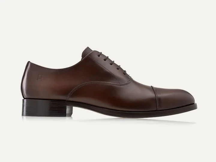 Sapato Oxford Neo Cap Toe Duplo na cor whisky, sobre fundo claro.