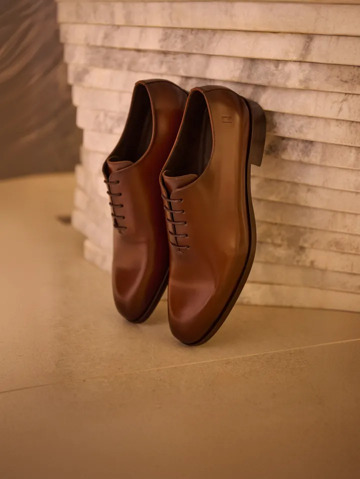 Sapato Oxford Wholecut sobre superfície de mármore.