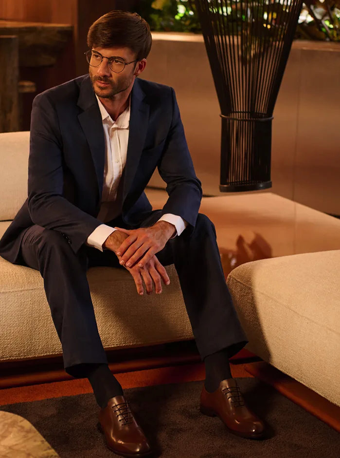 Homem em conversa, de perto, em ambiente de luz quente.